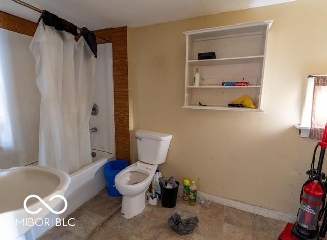 full bathroom featuring baseboards, toilet, and shower / bath combo with shower curtain