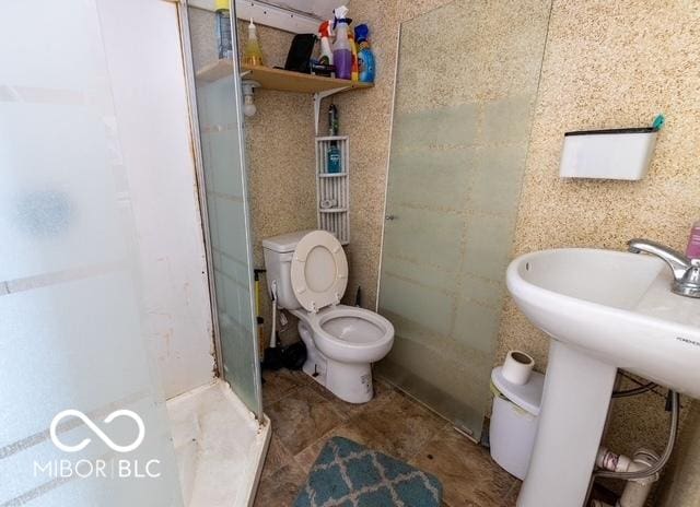 bathroom featuring toilet and a shower stall