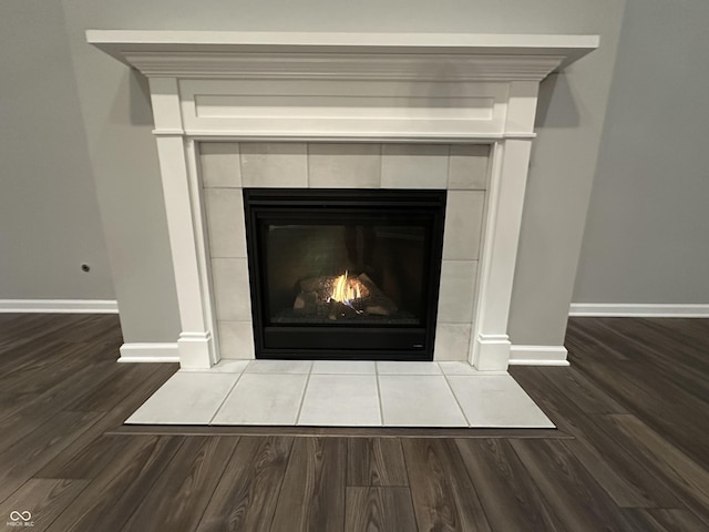 details featuring a fireplace, baseboards, and wood finished floors