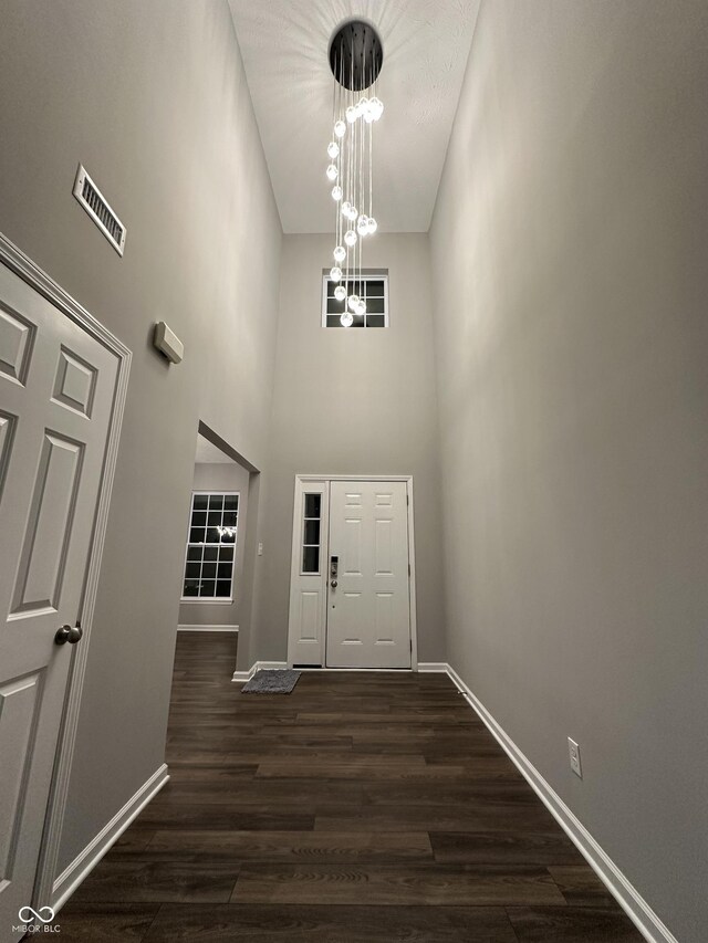 4187 Risen Star Way, Bargersville, IN 46106 - entryway with visible vents, baseboards, dark wood-type flooring, a high ceiling, and a notable chandelier