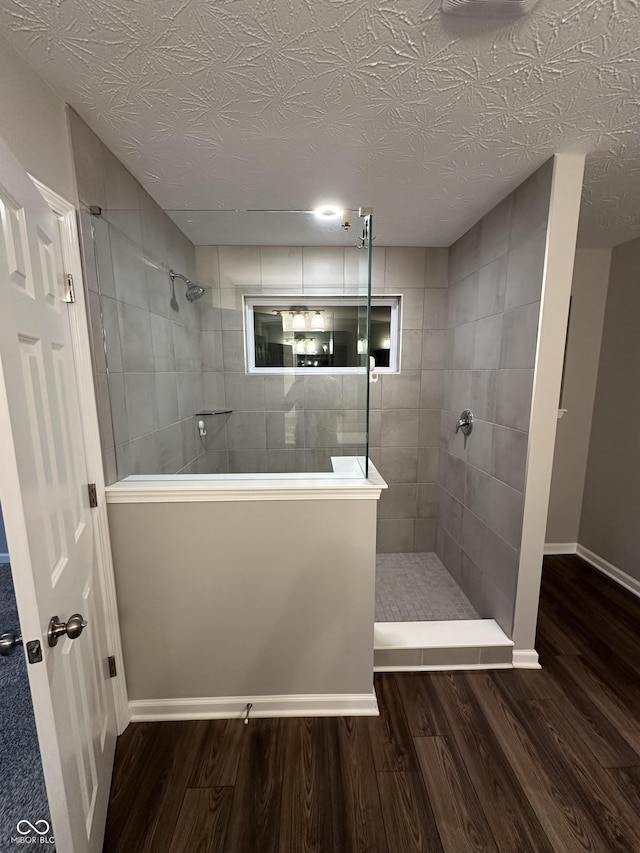 4187 Risen Star Way, Bargersville, IN 46106 - bathroom featuring baseboards, wood finished floors, a walk in shower, and a textured ceiling