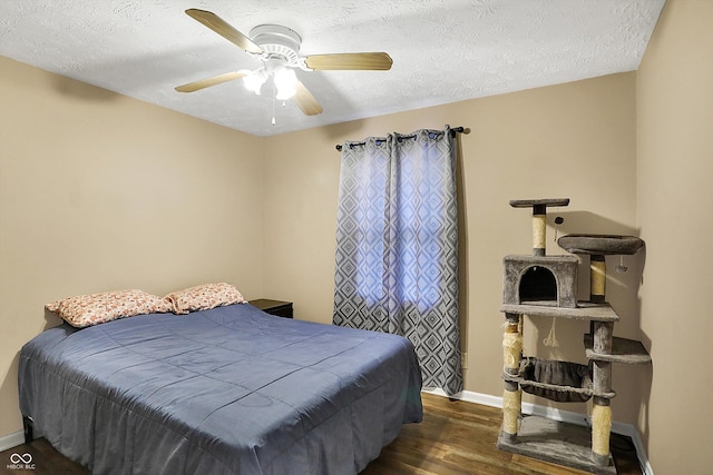 bedroom with dark wood-type flooring, ceiling fan, a textured ceiling, and baseboards