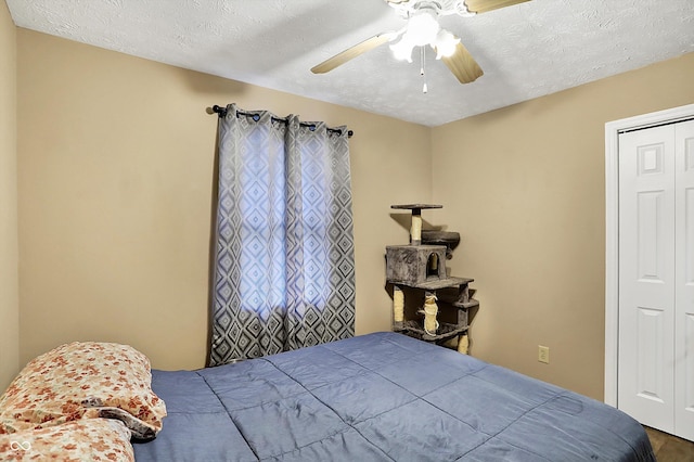 bedroom with a closet, ceiling fan, and a textured ceiling