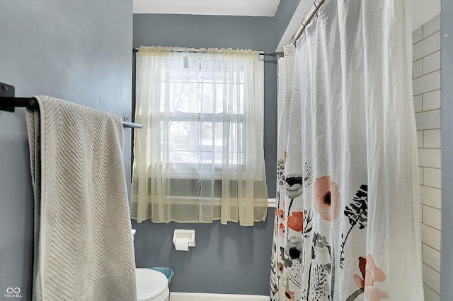 bathroom featuring toilet and baseboards