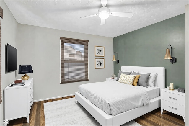 bedroom with dark wood-style floors and a ceiling fan