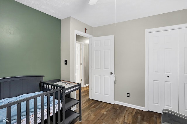 bedroom featuring ceiling fan, dark wood-type flooring, a closet, and baseboards