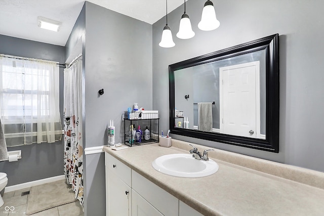 bathroom featuring toilet, tile patterned flooring, vanity, and baseboards