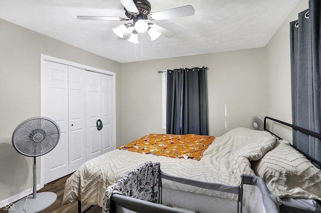 bedroom with dark wood-style floors, a closet, a textured ceiling, and a ceiling fan