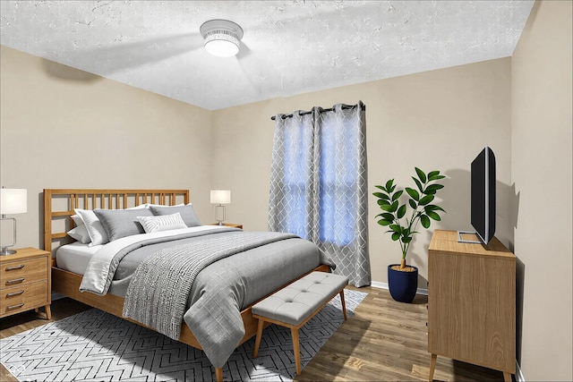 bedroom with a textured ceiling, baseboards, and wood finished floors