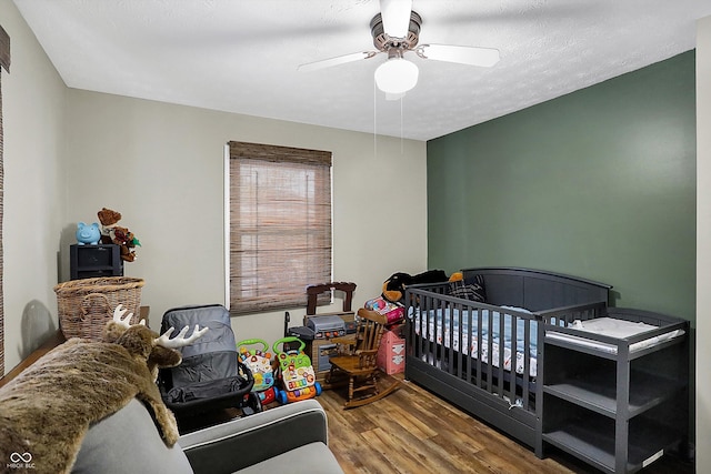 bedroom featuring a textured ceiling, wood finished floors, and a ceiling fan