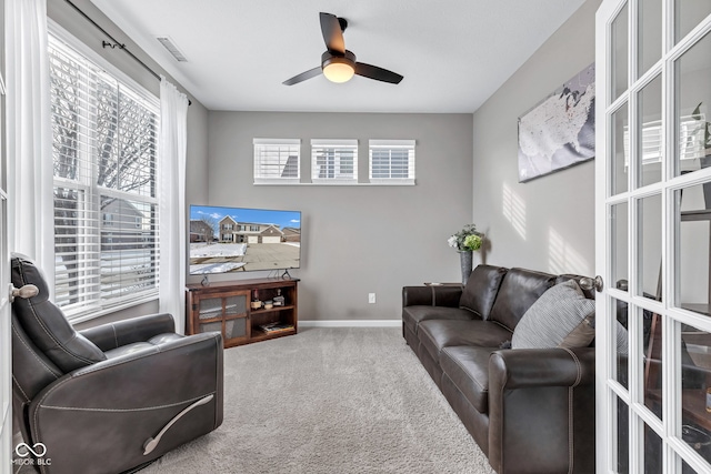 carpeted living area featuring ceiling fan, visible vents, and baseboards