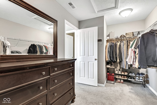 spacious closet featuring attic access, visible vents, and light colored carpet