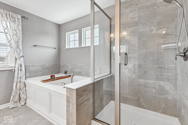 bathroom featuring a shower stall and a bath