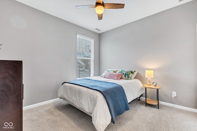 bedroom with light carpet, ceiling fan, visible vents, and baseboards