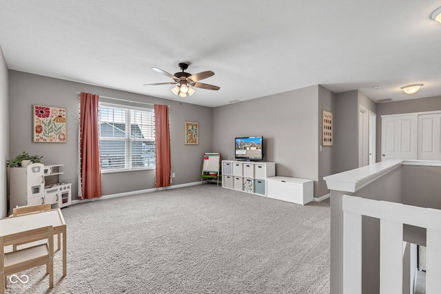 interior space with carpet, a ceiling fan, and baseboards