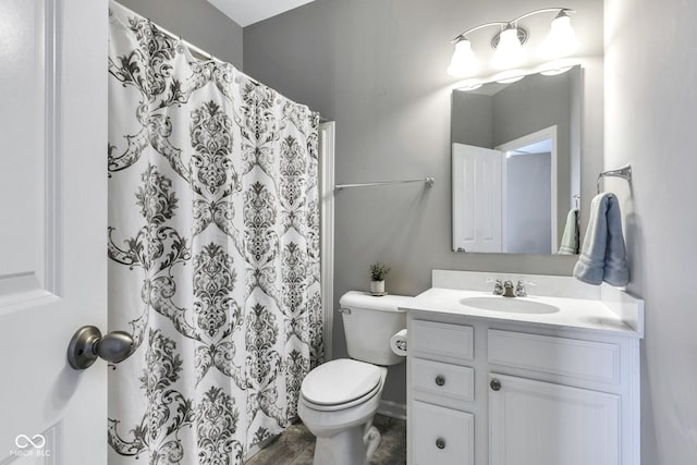 bathroom featuring toilet, vanity, and a shower with curtain