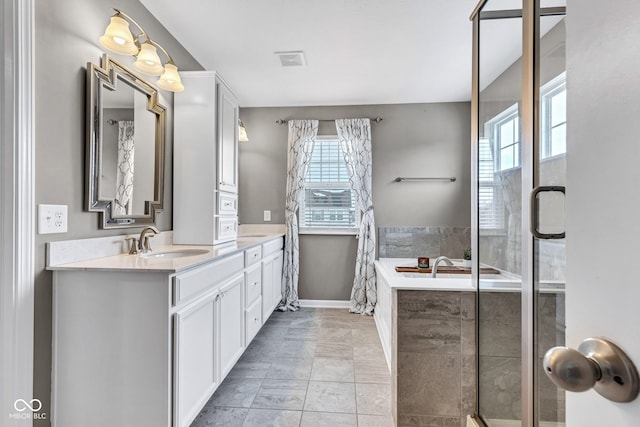 full bathroom featuring double vanity, visible vents, an enclosed shower, a sink, and baseboards