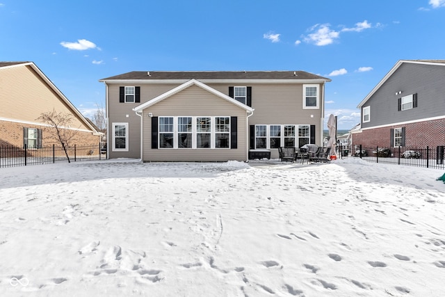 snow covered property with fence