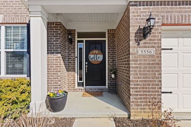 entrance to property featuring brick siding and an attached garage