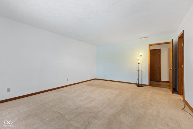 unfurnished room with light colored carpet, visible vents, and baseboards