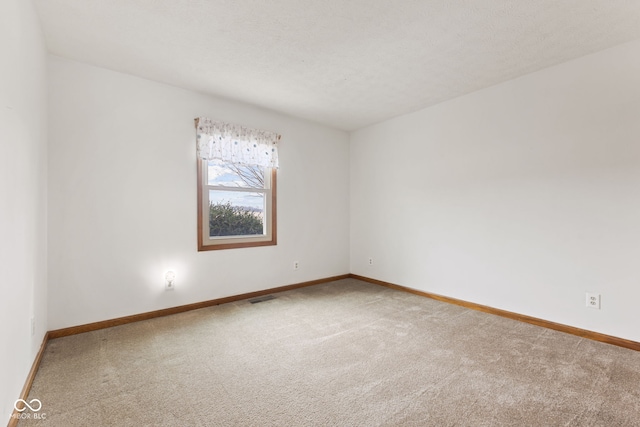 unfurnished room featuring carpet floors, baseboards, and visible vents