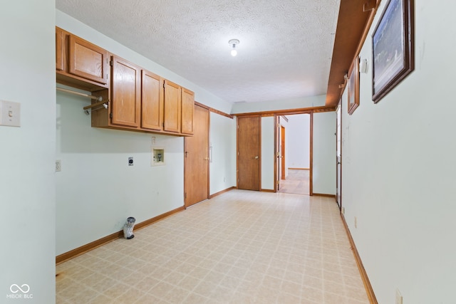 washroom featuring washer hookup, cabinet space, electric dryer hookup, a textured ceiling, and baseboards