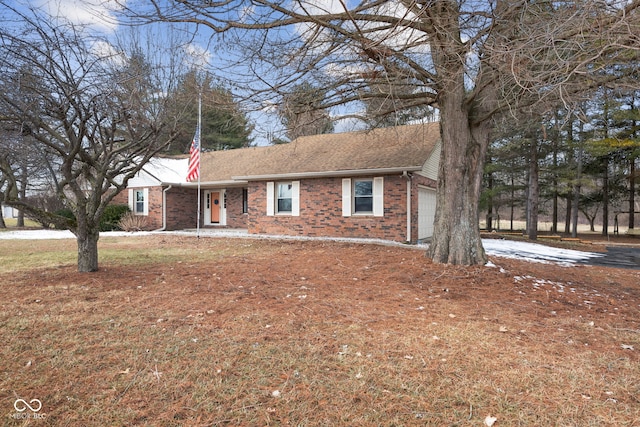 single story home with a garage, roof with shingles, and brick siding