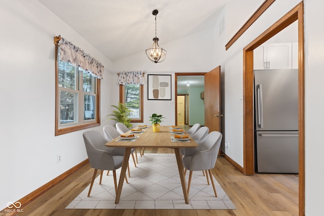 dining space featuring vaulted ceiling, light wood-type flooring, a chandelier, and baseboards