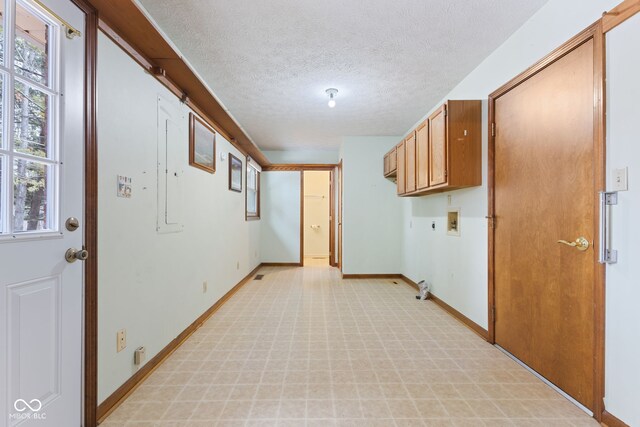 clothes washing area featuring a textured ceiling, plenty of natural light, hookup for a washing machine, and cabinet space