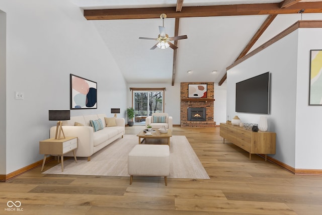 living room featuring a fireplace, beamed ceiling, light wood-style flooring, and baseboards