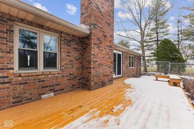 snow covered deck featuring fence