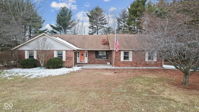 ranch-style house featuring roof with shingles, a front lawn, and brick siding