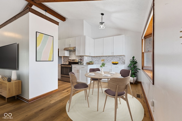 interior space with vaulted ceiling with beams, wood finished floors, and baseboards