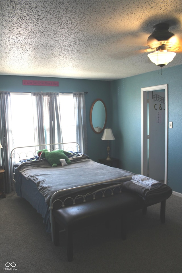 carpeted bedroom with ceiling fan, a textured ceiling, and baseboards