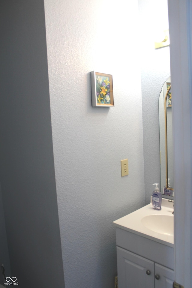 bathroom featuring a textured wall and vanity