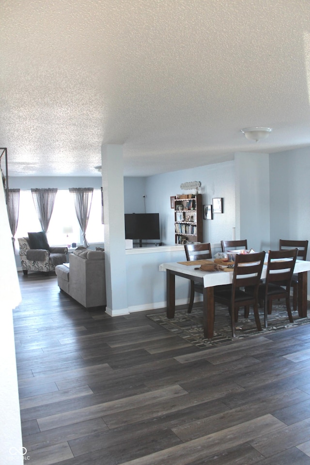 dining area featuring a textured ceiling, dark wood finished floors, and baseboards