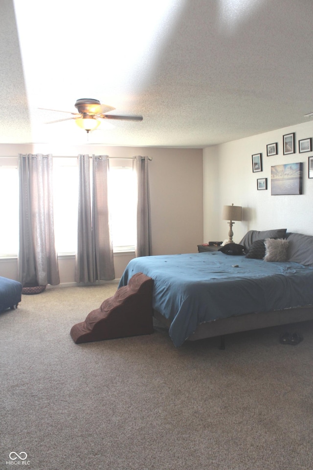 bedroom featuring a textured ceiling, carpet, and a ceiling fan