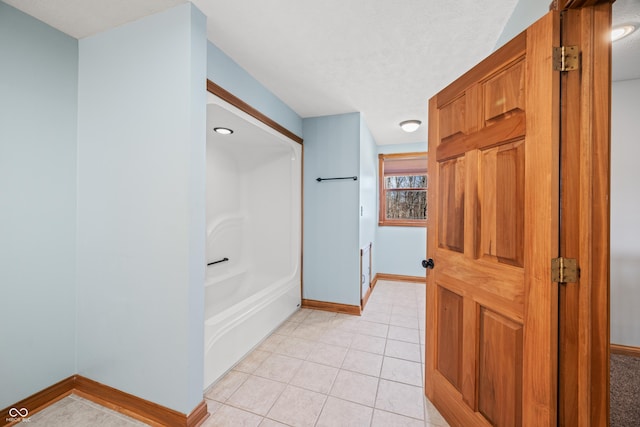 full bathroom featuring shower / bath combination, a textured ceiling, baseboards, and tile patterned floors