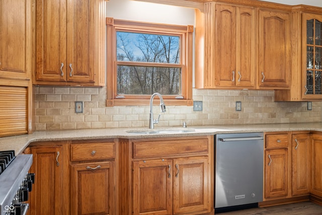 kitchen featuring stainless steel dishwasher, brown cabinets, and a sink