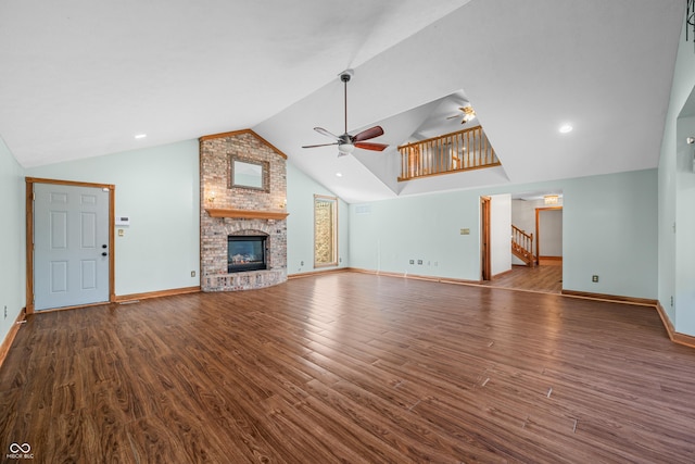 unfurnished living room with a ceiling fan, a fireplace, stairway, and wood finished floors