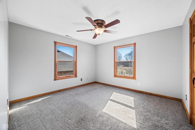 unfurnished room featuring carpet floors, visible vents, ceiling fan, and baseboards