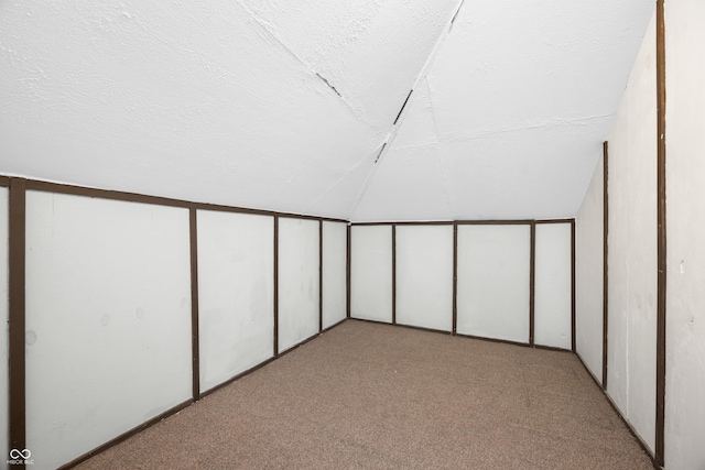 bonus room with carpet, vaulted ceiling, and a textured ceiling