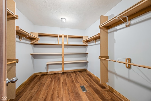 walk in closet featuring visible vents and wood finished floors