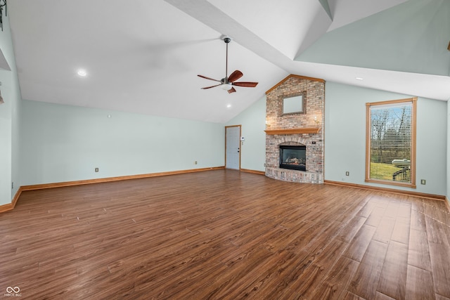 unfurnished living room with baseboards, a ceiling fan, lofted ceiling, wood finished floors, and a brick fireplace