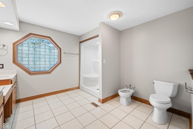 full bath with visible vents, toilet, a bidet, vanity, and baseboards