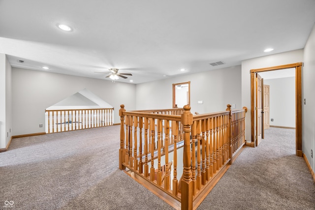 hall with carpet floors, baseboards, visible vents, and recessed lighting