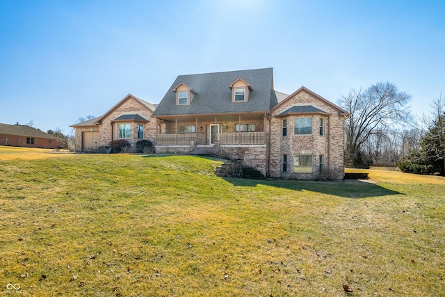 view of front facade featuring covered porch, a front lawn, and brick siding