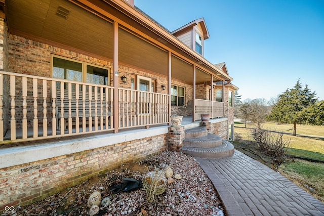 view of home's exterior featuring covered porch and brick siding