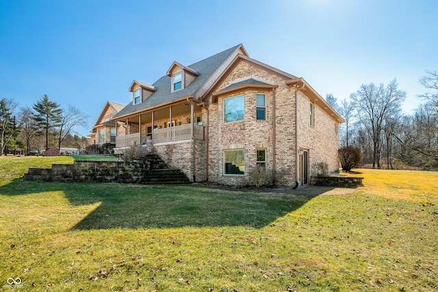 rear view of house with a lawn and brick siding