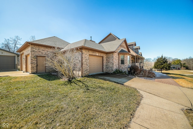 french country home with a garage, brick siding, driveway, and a front lawn